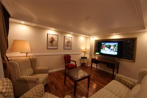 a living room with couches and a flat screen tv at Golden Apartments in Essen