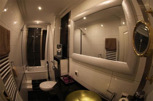 ein Badezimmer mit einem Waschbecken, einem WC und einem Spiegel in der Unterkunft Golden Apartments in Essen
