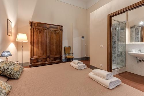 a bedroom with a bed with a sink and towels at Appartamenti Villa Mascagni in Volterra