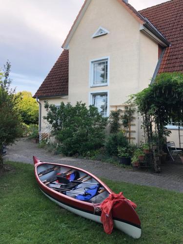 a canoe sitting on the grass in front of a house at Ferienwohnung Seeblick Ratzeburg in Ratzeburg