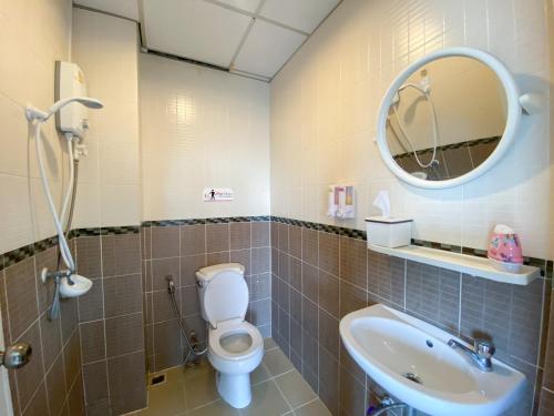 uma casa de banho com um WC, um lavatório e um espelho. em Uh Hostel em Bangsaen
