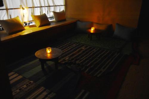 a dark room with two tables and a bed with candles at Riad Anma in Taroudant