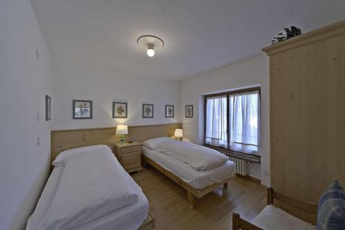 - une chambre avec 2 lits et une fenêtre dans l'établissement Chesa Centrum - Celerina, à Celerina