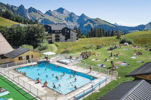 a group of people in a swimming pool in a field at Appartement la Clusaz avec terrasse sur les pistes de ski in Manigod