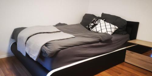 Una cama negra con dos almohadas encima. en SLEEP WELL Apartments, FEWO Falkenburg, en Detmold