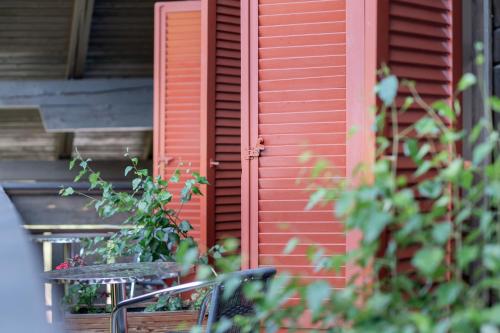 a red building with a table and chairs in front of it at Rooms Kronblick in San Lorenzo di Sebato