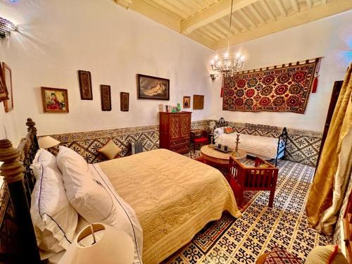 a bedroom with a large bed and a couch at Riad De La Mer in Essaouira