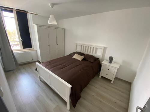 - une chambre blanche avec un grand lit et une fenêtre dans l'établissement Joli appartement avec parking gratuit sur place, à Givet
