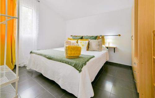 a bedroom with a bed with a yellow basket on it at Awesome Home In El Coronil With Wifi in El Coronil