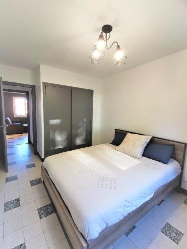 une chambre avec un grand lit blanc dans une pièce dans l'établissement Appartement tout confort refait à neuf, à Moulins