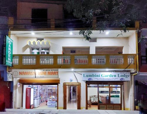 a white building with a balcony on top of it at Lumbini Garden Lodge in Lumbini