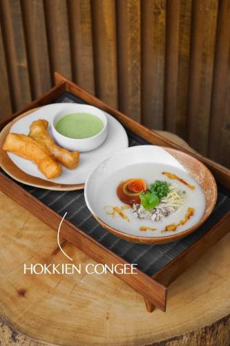 a tray with two plates of food and french fries at Goose Living in Bangkok
