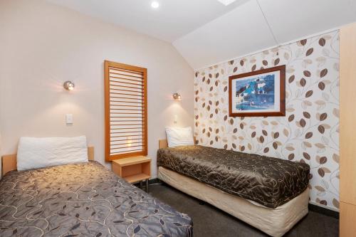 a bedroom with two beds and a window at Midtown Tui Villa - Taupō Central Holiday Unit in Taupo
