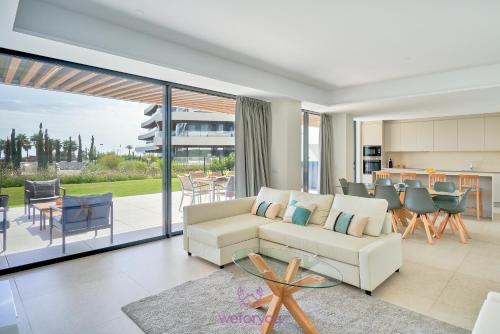 a living room with a white couch and a kitchen at weforyou Las Nereidas de Los Álamos 3 bedrooms and PARKING in Torremolinos
