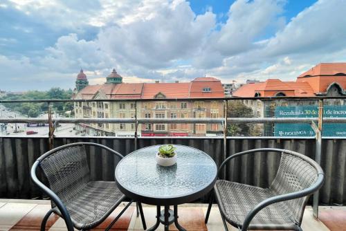 a table and chairs on a balcony with a building at City Center View Studio Apartment 1 in Timişoara