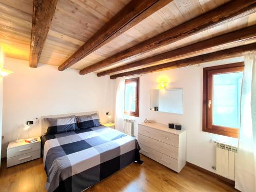 a bedroom with a black and white bed and a mirror at Ca' Nova - Burano in Burano