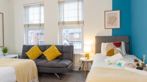 1 dormitorio con 2 camas y sofá en Air Host and Stay - Daisy House - Large 3 bedroom sleeps 7 10 minutes from city centre en Liverpool
