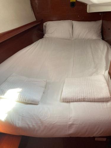 a white bed with two folded towels on it at Sea Bloom - Sleep & Sail in Tejo in Lisbon