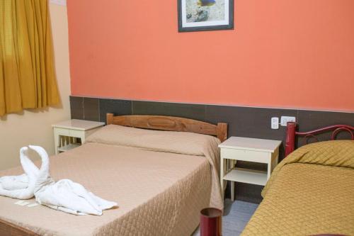 two beds in a room with orange walls at Hotel Atlantic in Mar del Plata