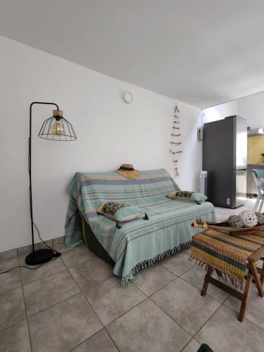 een witte kamer met een bed en een lamp bij CASSIOPEE in Saint-Gilles-les-Bains