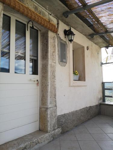 a white garage door on a house with a window at Molise isernia è casa Sbriglio, tra cascate, laghi, fiumi e relax in Sessano Del Molise