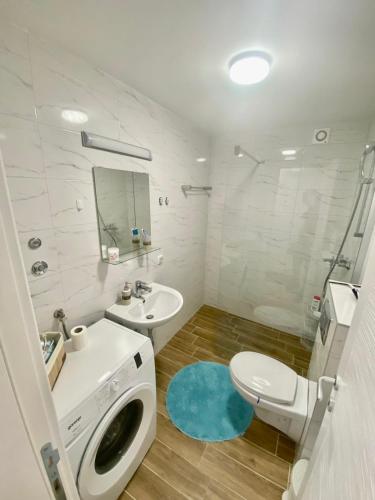 a white bathroom with a toilet and a sink at BellaVista apartman in Stara Pazova