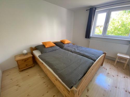 a bedroom with a wooden bed in a room with a window at Ferienhaus Halbritter Krina in Krina