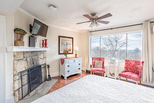 a bedroom with a fireplace and two red chairs at Echo Mountain Inn in Hendersonville