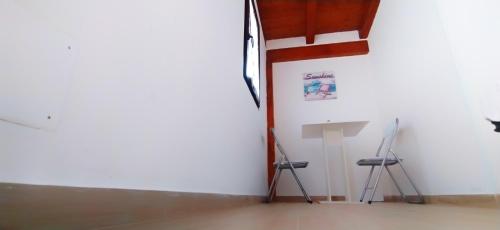 una stanza con due sedie e un tavolo e un muro di Casa Giada sul mare a Torrenova