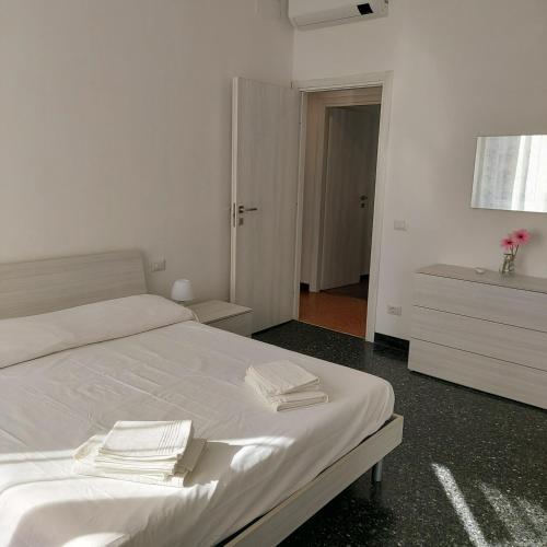 um quarto com uma cama branca e toalhas em SEA COTTAGE em Savona