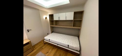 a small bedroom with a bed and a skylight at Luxusní apartmán GRAND v centru Harrachova se saunou, wallboxem EV, parkováním zdarma, Netflix a HBO, velkým balkonem a výhledem na Čertovu horu ,sjezdovku a skokanské můstky in Harrachov
