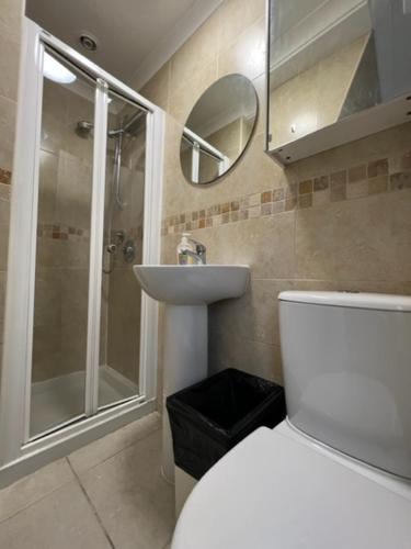 a bathroom with a toilet and a sink and a shower at ApartaSuites London Emerald in London