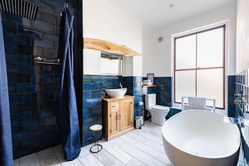 a bathroom with a tub and a toilet and a sink at Villa Otto - Norfolk Holiday Properties in Cromer