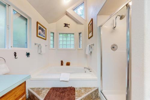 a white bathroom with a tub and a shower at Marcia's Mercer Lake Chateau in Florence