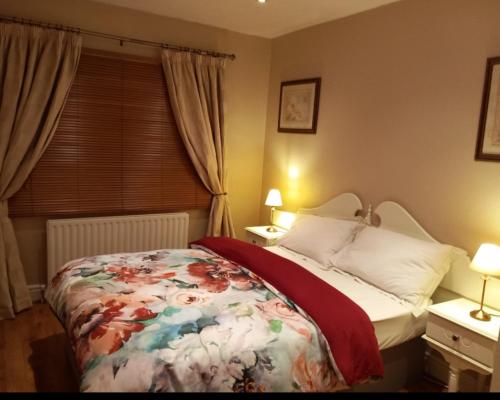 a bedroom with a bed with a floral blanket on it at Mels accomodation in Letterkenny