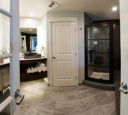 a bathroom with a shower and a white door at Cannery Pier Hotel & Spa in Astoria, Oregon
