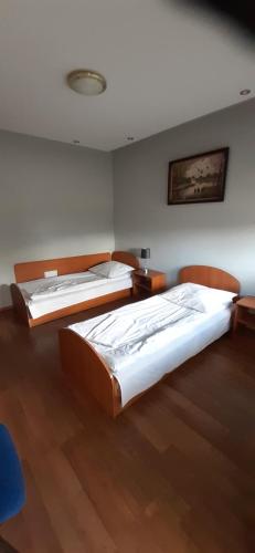 2 łóżka w pokoju z drewnianą podłogą w obiekcie Motel przy stacji paliw Amic w mieście Stradomia Wierzchnia
