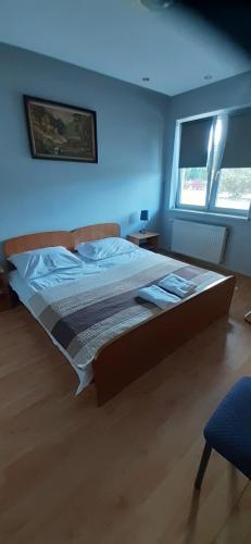 a large bed in a bedroom with a blue wall at Motel przy stacji paliw Amic in Stradomia Wierzchnia