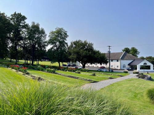 a garden with flowers and a house in the background at Hershey Farm Resort in Ronks