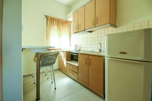 a kitchen with a refrigerator and a chair in it at Zinozis Beach Apartments in Vourvourou