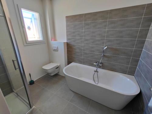 une salle de bain avec baignoire et toilettes dans l'établissement Villa Vias Plage, à Vias