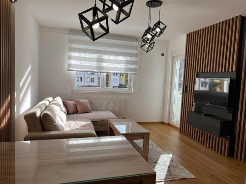 a living room with a couch and a tv at Stan na dan Lorena in Sarajevo