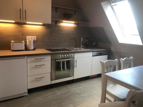 a kitchen with a stove and a sink and a table at Wohnung mit Fernblick und Parkplatz in Jübek