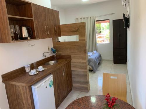 a kitchen with wooden cabinets and a sink and a table at Las Salinas Hostal in Luque