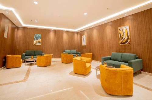 a waiting room with yellow and green chairs at DiYar Home Hotel in Baljurashi