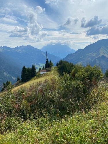 a grassy hill with a church on top of it at Hideaway Zugspitz Berwang in Berwang
