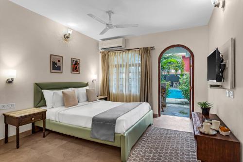 a hotel room with a bed and a television at La Vaiencia Beach Resort, Morjim Beach in Morjim