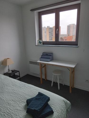 a bedroom with a bed and a desk and a window at Roubaix près Lille, un cocon en plein centre in Roubaix