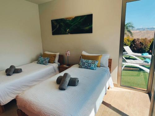 Cette chambre comprend 2 lits jumeaux et un balcon. dans l'établissement Villa Lía by SunHousesCanarias, à Salobre