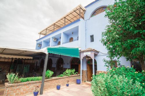 un gran edificio blanco con toldo verde en Hotel TOURAGHINE, en Chefchaouen